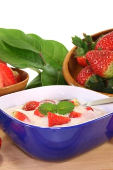 Strawberry yogurt with fresh strawberries on a wooden board