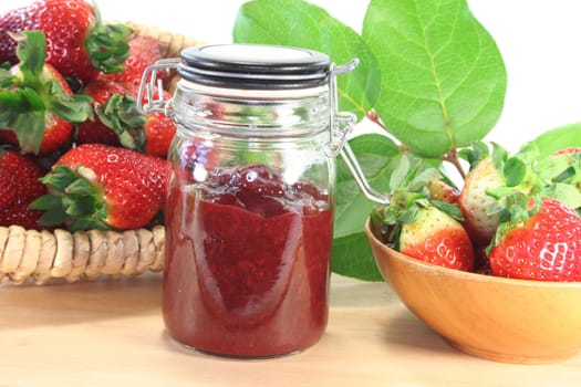 Strawberry jam with fresh strawberries on a wooden board