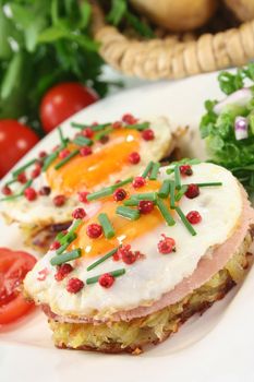 Potato pancakes with ham, egg, red pepper, chives and fresh salad