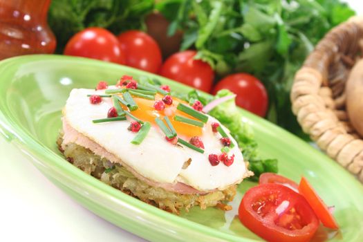 Potato pancakes with ham, egg, red pepper, chives and fresh salad