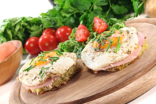 Potato pancakes with ham, egg, pepper, chives and fresh salad