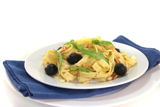 Pasta with pine nuts, pesto, olives and fresh rocket