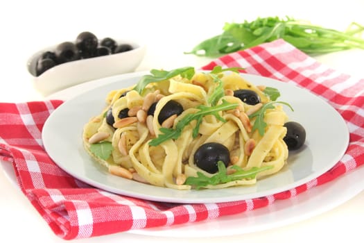 Pasta with pine nuts, pesto, olives and fresh rocket