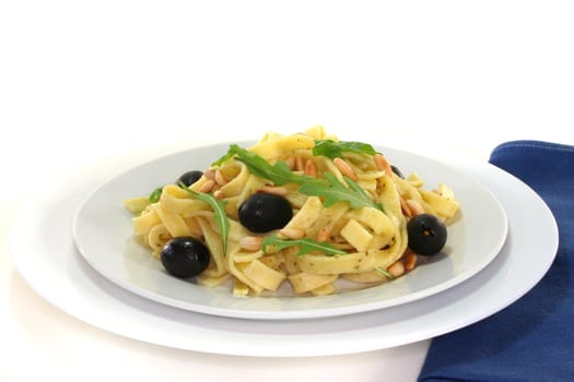 Pasta with pine nuts, pesto, olives and fresh rocket