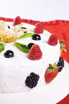 Piece of cake on plate with berries and fruits