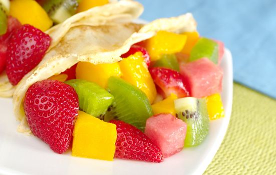 Crepes filled with fresh fruits (strawberry, kiwi, mango, watermelon) (Selective Focus, Focus on the fruits in the lower left corner)