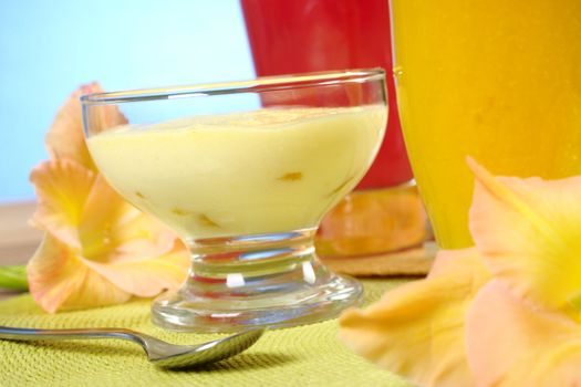 Light summer cream-cheese-mango dessert with mango and watermelon smoothies and gladiolus flowers (Selective Focus, Focus on the front of the dessert)