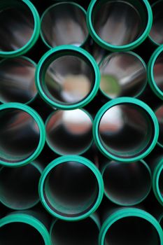 a stack of green pipes in a construction zone