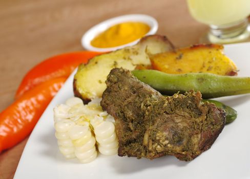 Pachamanca, which is a traditional meal from the Peruvian highlands, is made of different kinds of meat with beans and corn as well as potatoes and sweet potatoes, and is traditionally cooked in the ground (Selective Focus, Focus on the upper right part of the meat) 