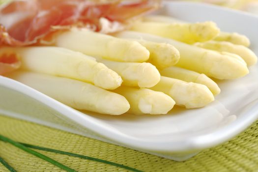 Fresh cooked white asparagus served with ham (Selective Focus, Focus on the front of the asparagus on the left)