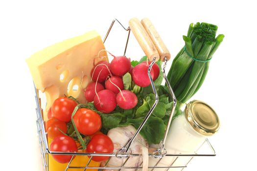 Shopping cart with milk, cheese and mixed vegetables