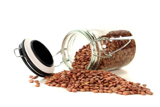 dried lentils in a glass on a white background