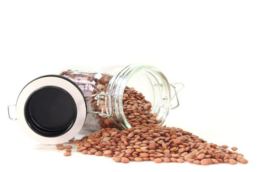 dried lentils in a glass on a white background