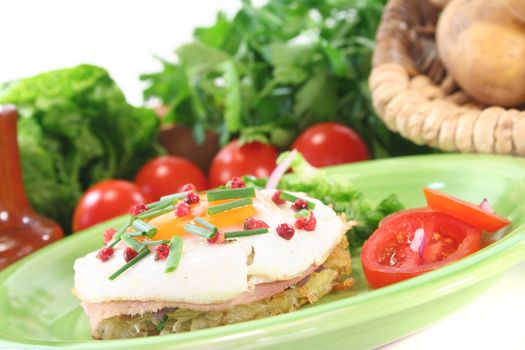 Potato pancakes with ham, egg, red pepper, chives and fresh salad