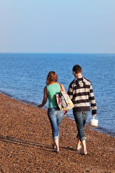 couple walking away from camera on beach