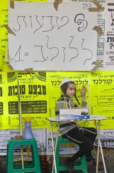 JERUSALEM - OCT 10 : An ultra-orthodox Jewish child sells Lulav's ring in the "Four spesies" market in Jerusalem Israel on October 10 2011 , Lulav is one of the "Four spesies"  used during the celebration of Sukot