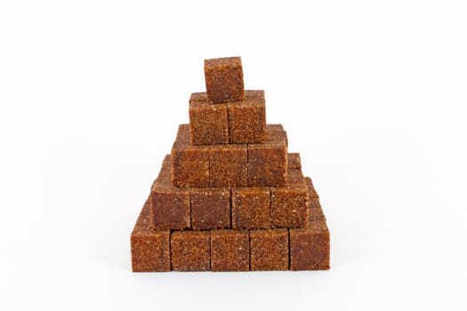 Pyramid made of cane sugar cubes isolated on white