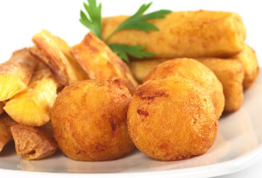 Filled fried balls and sticks out of manioc (Selective Focus, Focus on the manioc ball in the front)