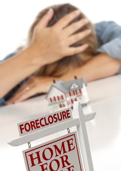 Woman with Head in Hand Behind Model Home and Foreclosure Real Estate Sign in Front.