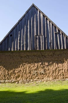 Ancient house with mole walls and wooden roof. Retro architectural decisions.