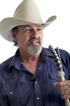 Cowboy holding a bullwhip around his shoulder. Isolated on white