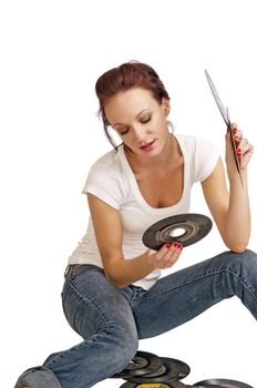 Attractive young woman looking through her vintage records for a rock and roll song to play.