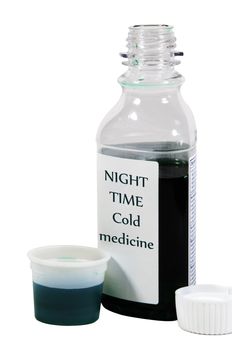 Over the counter night-time cold medicine in a dosage cup. Isolated on white with a clipping path