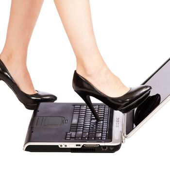 Woman kicking a laptop computer with her highheel shoe.