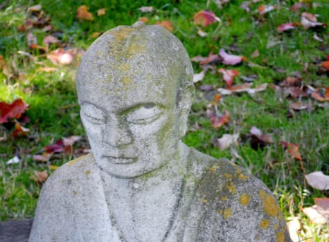 Buddha gathering moss sitting by the water in the shade of the bodhi tree.