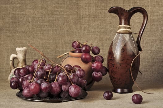 Grapes red and ceramic ware against a canvas
