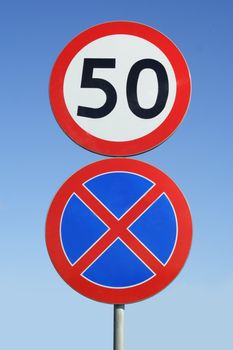 two road signs on background of blue sky 