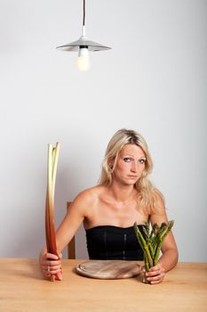 young woman sitting with rhubarb and asparagus