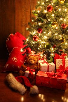 Closeup of brightly lit Christmas tree with gifts