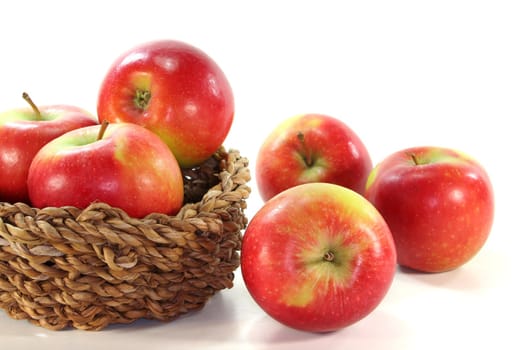 red and yellow apples in the basket before a white background