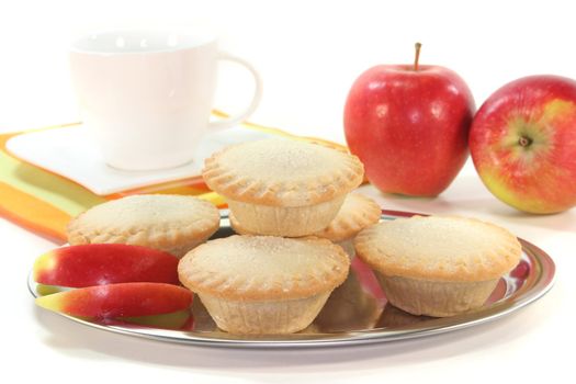 Apple pie on a silver platter in front of white background