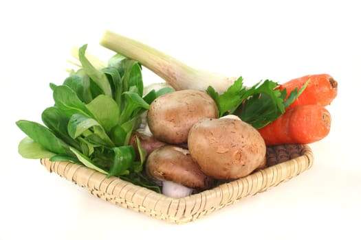 Corn salad, parsley root, mushrooms, carrots, parsley and garlic in the basket on a white background