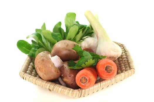 Corn salad, parsley root, mushrooms, carrots, parsley and garlic in the basket on a white background