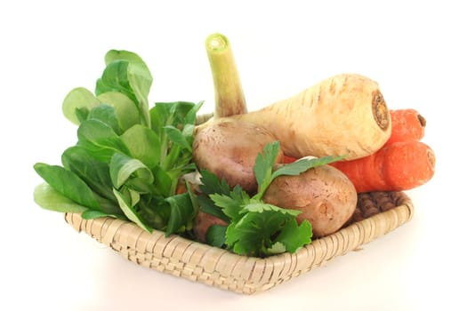Corn salad, parsley root, mushrooms, carrots, parsley and garlic in the basket on a white background