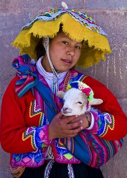 CUSCO , PERU - MAY 27 : Unidentified Peruvian girl in traditional colorful clothes holding a lamb in here arms in the " Unesco world heritage" city "Cusco" on May 27 2011