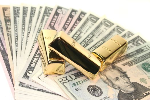 three large gold bars on many dollar bills