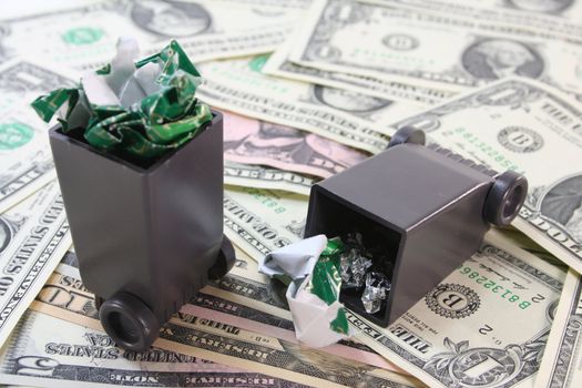 full garbage cans with dollar bills before a white background