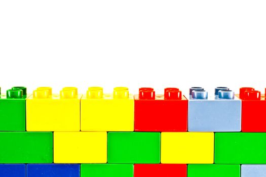 Plastic building blocks on white background. Bright colors.