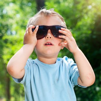 Cute 2 years old boy Sunglasses outdoors at sunny summer day