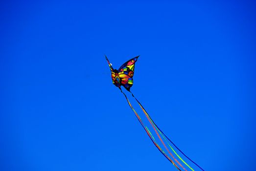 A colorful butterfly kite flying on a clear summer day