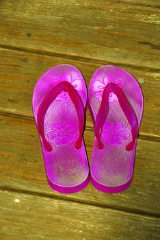 A pair of flip flops on a wooden deck