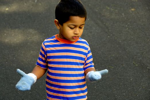 An handsome Indian kid looking at the new mittens