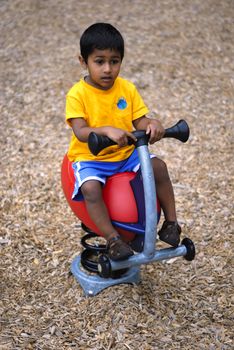 an handsome Indian child happy playing in the play area