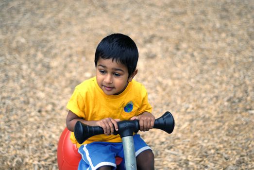 an handsome Indian child happy playing in the play area