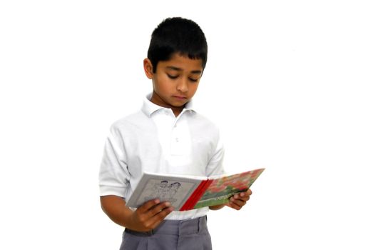 an handsome indian kid reading a book at school