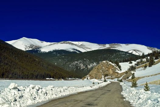 The snow covered Colorado Rocky Mountains with blue sky seem to come to life along Guanella Pass